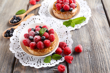 Sweet cakes with berries on table close-up