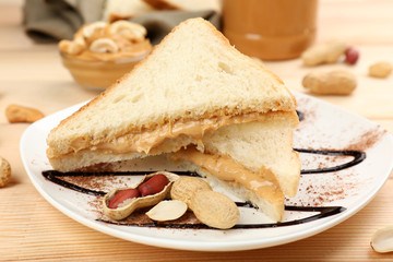 Bread slices with creamy peanut butter on wooden table