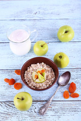 Bowl of oatmeal, dried apricots, apples and yogurt