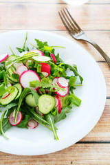 arugula, cucumber and radishes in a salad