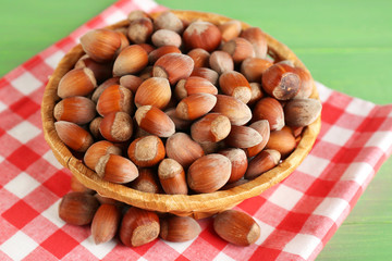 Hazelnuts on wicker mat on wooden background