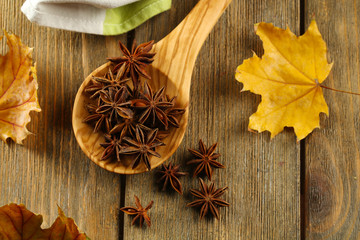 Stars anise in wooden spoon on table close up