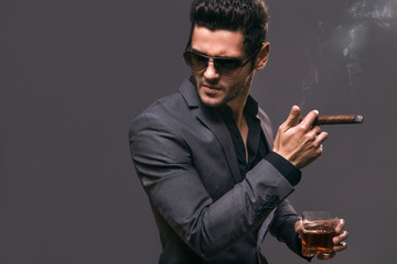 Hard gaze businessman while smoking a cuban cigar