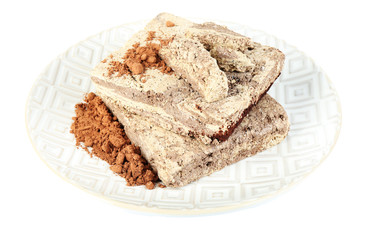 Sunflower halva with cocoa on plate isolated on white
