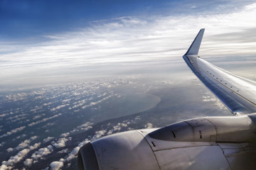 Wing of an airplane flying above the clouds