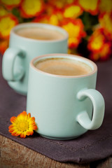 Cup of coffee with bright autumn flowers