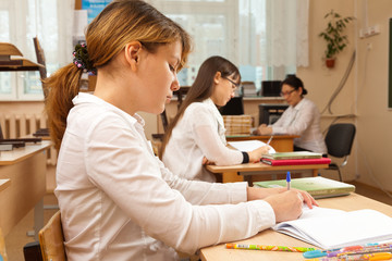 Student girls during optional lesson before exam in classroom.