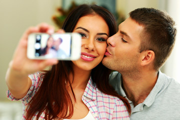 Portrait of a happy couple making selfie photo with smarphone