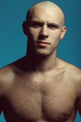 Male beauty concept. Handsome bald model with earring posing