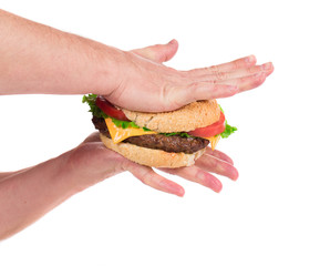 Hands press juicy hamburger.