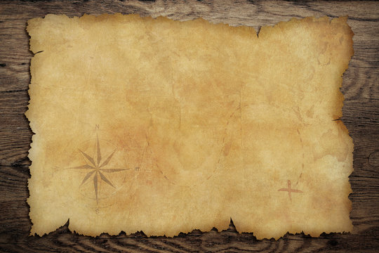 Pirates' old parchment treasure map on wood table