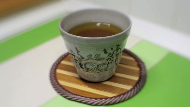 Una mano mette una tazza di t&egrave; su tavolo