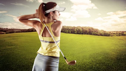 Rolgordijnen Young female in sportswear playing golf on green field © Stasique