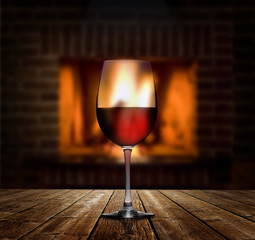 Rotweinglas vor Kaminfeuer