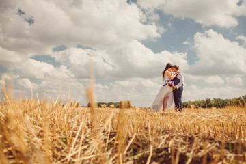 bride and groom with veil near hay