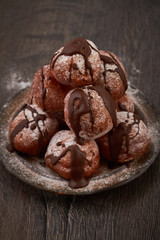 Small homemade doughnuts covered with chocolate sauce