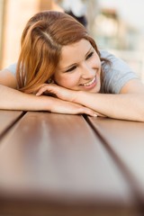 Obraz na płótnie Canvas Smiling casual redhead lying on bench