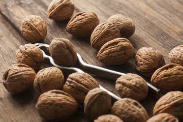 nutcracker with walnuts over wooden surface