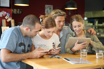 Students in campus lounge websurfing on tablet