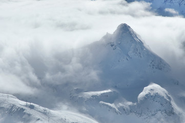 Fototapeta na wymiar Winter in the Alps with clouds above the mountains
