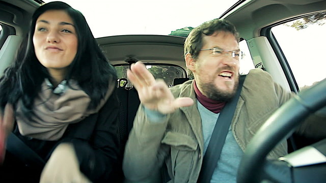 Man and woman dancing crazy in car being stupid