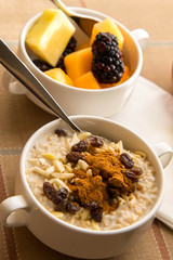 Fresh fruit and oatmeal with healthy toppings for breakfast