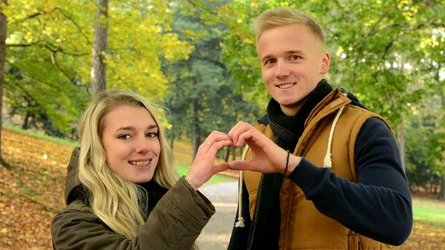 couple forms a heart with their hands - happy couple kiss