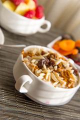 Fresh fruit and oatmeal with healthy toppings for breakfast
