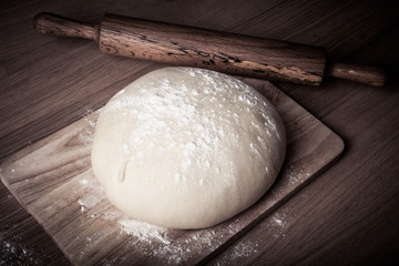 dough with rolling pin on wood table.Tinted