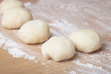 Fototapeta na wymiar Small balls of dough with flour for pizza or cakes and scones. S