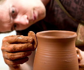 hands of a potter, creating an earthen jar
