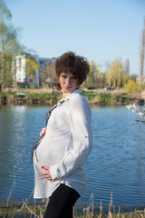 Fototapeta na wymiar The pregnant girl on walk in city park