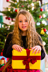 Mädchen mit Weihnachtsgeschenk an Heiligabend 