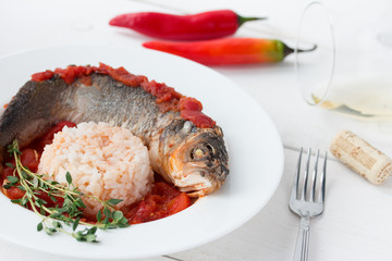 Steamed sea bass in tomato sauce with chili pepper.