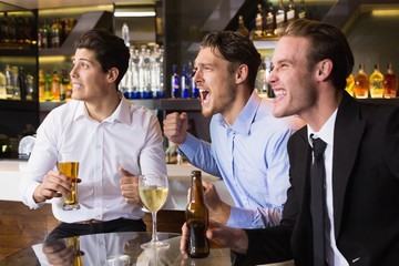 Handsome friends having a drink together