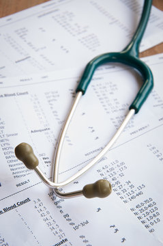 A Stethoscope On The Top Of A Blood Test Result