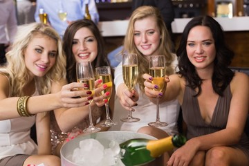 Pretty friends drinking champagne together