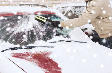 closeup of man cleaning snow from car