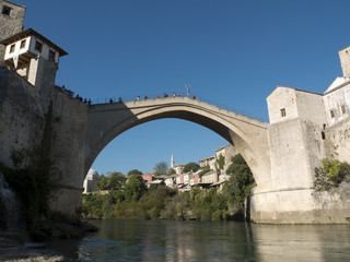 Fototapeta na wymiar Plongeur, bras levés, sur le pont de Mostar en Bosnie.