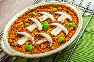 Chicken baked with rice, mushrooms and tomatoes