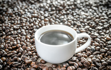Cup of coffee on coffee beans