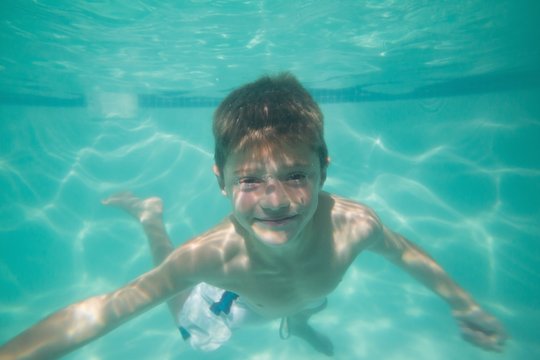 Cute kid posing underwater in pool