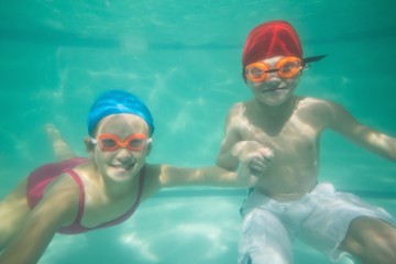 Obraz na płótnie Canvas Cute kids posing underwater in pool