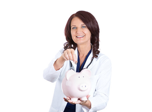 Doctor holding piggy bank isolated on white background 
