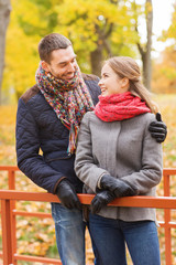 Fototapeta premium smiling couple hugging on bridge in autumn park
