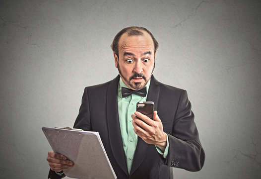 surprised business man reading bad news on smartphone