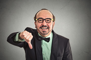 Happy guy showing thumbs down hand gesture on grey background 