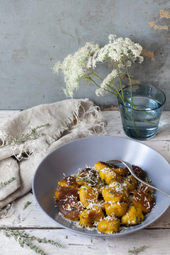 homemade pumpkin dumplings with parmesan on table with flowers