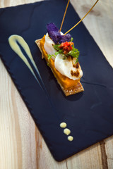 Saint-Jacques scallops, carrots puree and biscuit on a plate