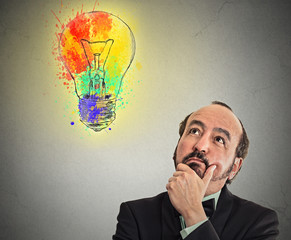Man with thoughtful expression and light bulb over his head